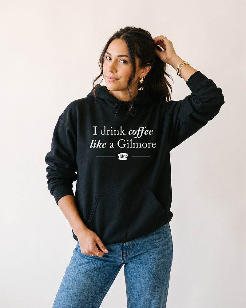 Woman wearing black I Drink Coffee Like a Gilmore hoodie inspired by Luke's Diner and Stars Hollow