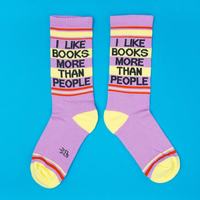 Pair of purple I Like Books More Than People novelty socks with yellow heels, toes and orange striped details