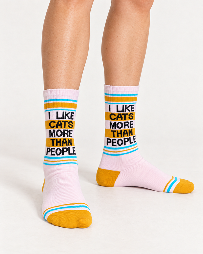 Model wearing I Like Cats More Than People gym socks in blush pink with yellow toes and turquoise stripes