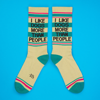 Pair of I Like Dogs More Than People yellow crew socks with bold lettering and teal heels and toes