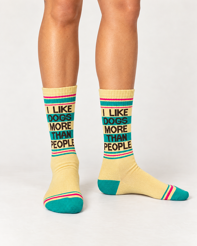 Model wearing I Like Dogs More Than People yellow gym socks with teal and pink retro stripes