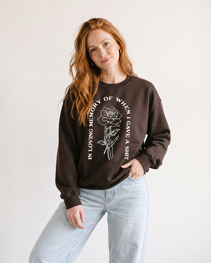 Woman wearing dark chocolate In Loving Memory sarcastic graphic crewneck sweatshirt