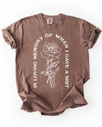 Espresso garment-dyed heavyweight tee with In Loving Memory skeleton hand and rose graphic in white