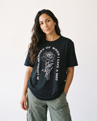 Brunette woman wearing In Loving Memory lightweight graphic tee in Black Heather with white skeleton rose design