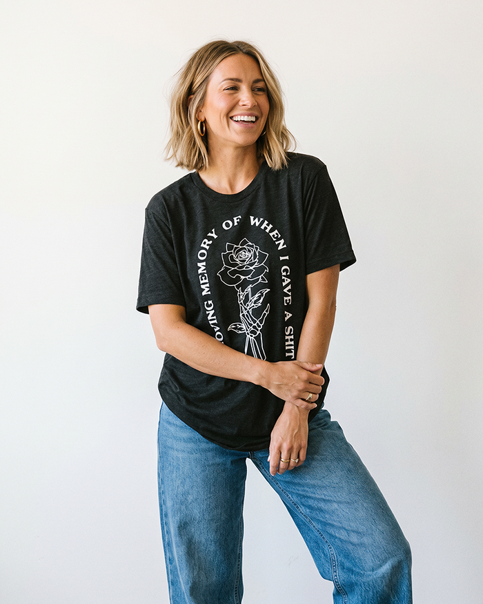 Woman wearing Black Heather In Loving Memory lightweight graphic tee with skeleton hand and rose artwork