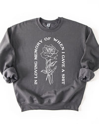 Charcoal In Loving Memory crewneck sweatshirt with white skeleton hand and rose graphic