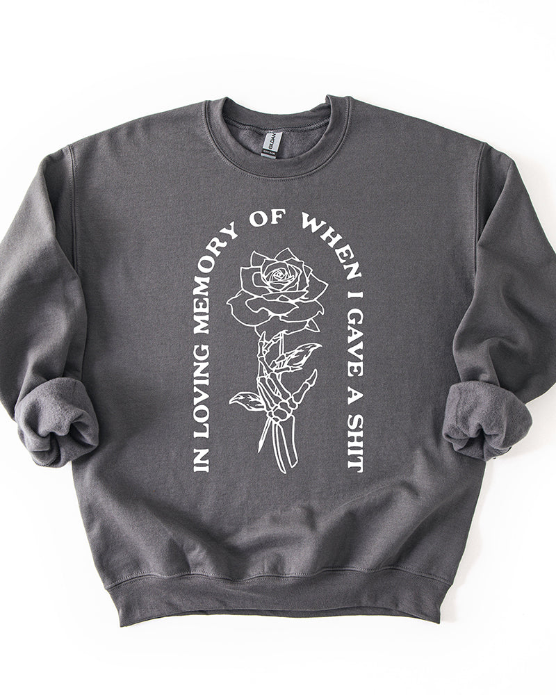 Charcoal In Loving Memory crewneck sweatshirt with white skeleton hand and rose graphic