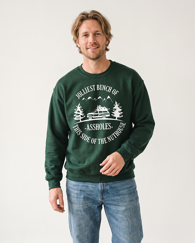 Man wearing forest green Jolliest Bunch of Assholes Christmas sweatshirt