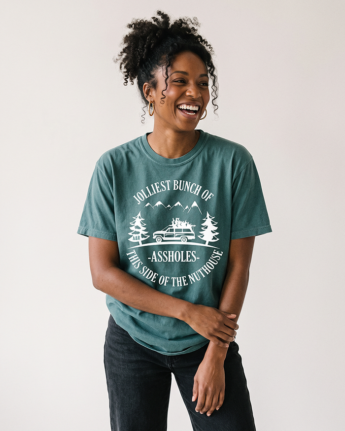 Woman wearing blue spruce Jolliest Bunch of Assholes funny Christmas tee
