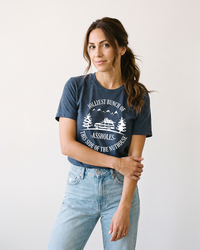 Woman wearing navy Jolliest Bunch of Assholes funny holiday tee