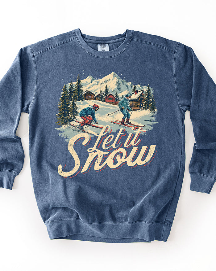 Denim blue garment-dyed heavyweight sweatshirt with vintage ski resort illustration and large distressed Let It Snow lettering.