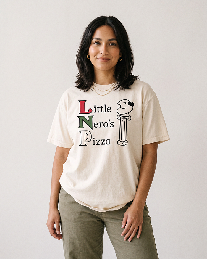 Woman wearing an ivory Little Nero's Pizza heavyweight cotton tee with olive green pants.