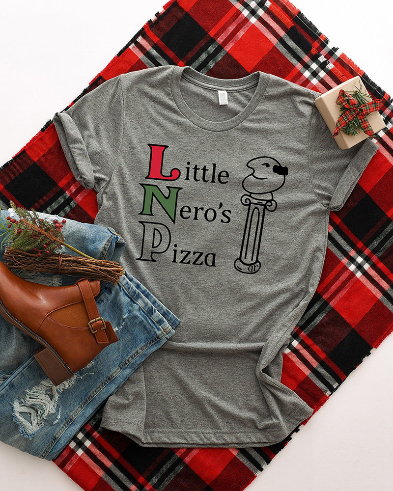 Little Nero's Pizza Christmas graphic tee styled with plaid fabric, jeans, boots and a wrapped holiday gift.