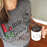 Close-up of a heather gray Little Nero's Pizza Home Alone inspired graphic tee worn with a coffee mug.