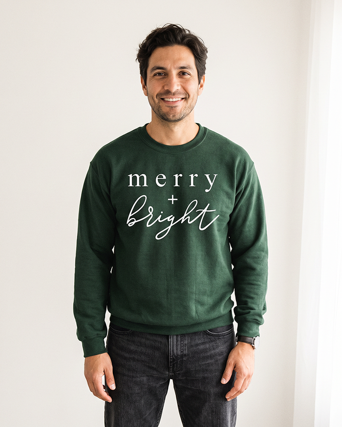 Man wearing forest green Merry + Bright Christmas crewneck sweatshirt
