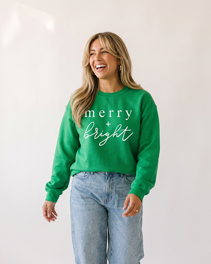 Woman wearing Irish green Merry + Bright Christmas sweatshirt