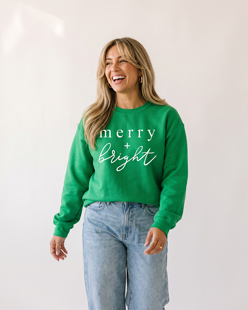 Woman wearing Irish green Merry + Bright Christmas sweatshirt