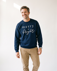 Man wearing navy Merry + Bright unisex Christmas sweatshirt