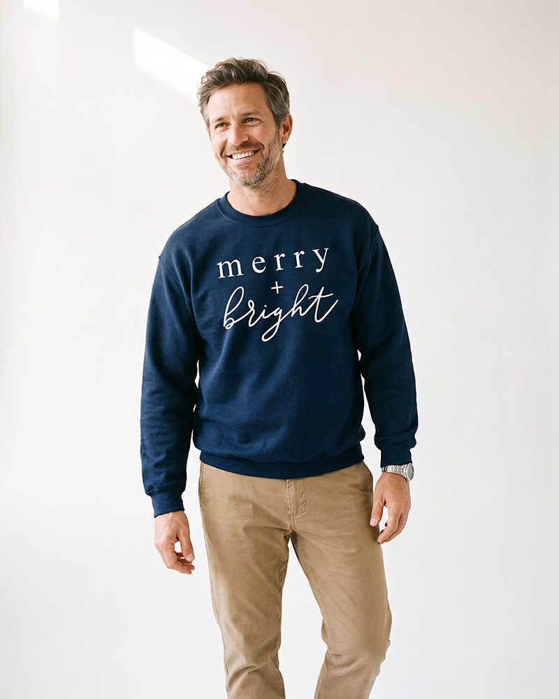 Man wearing navy Merry + Bright unisex Christmas sweatshirt