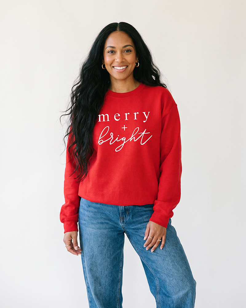 Woman wearing red Merry + Bright Christmas crewneck sweatshirt