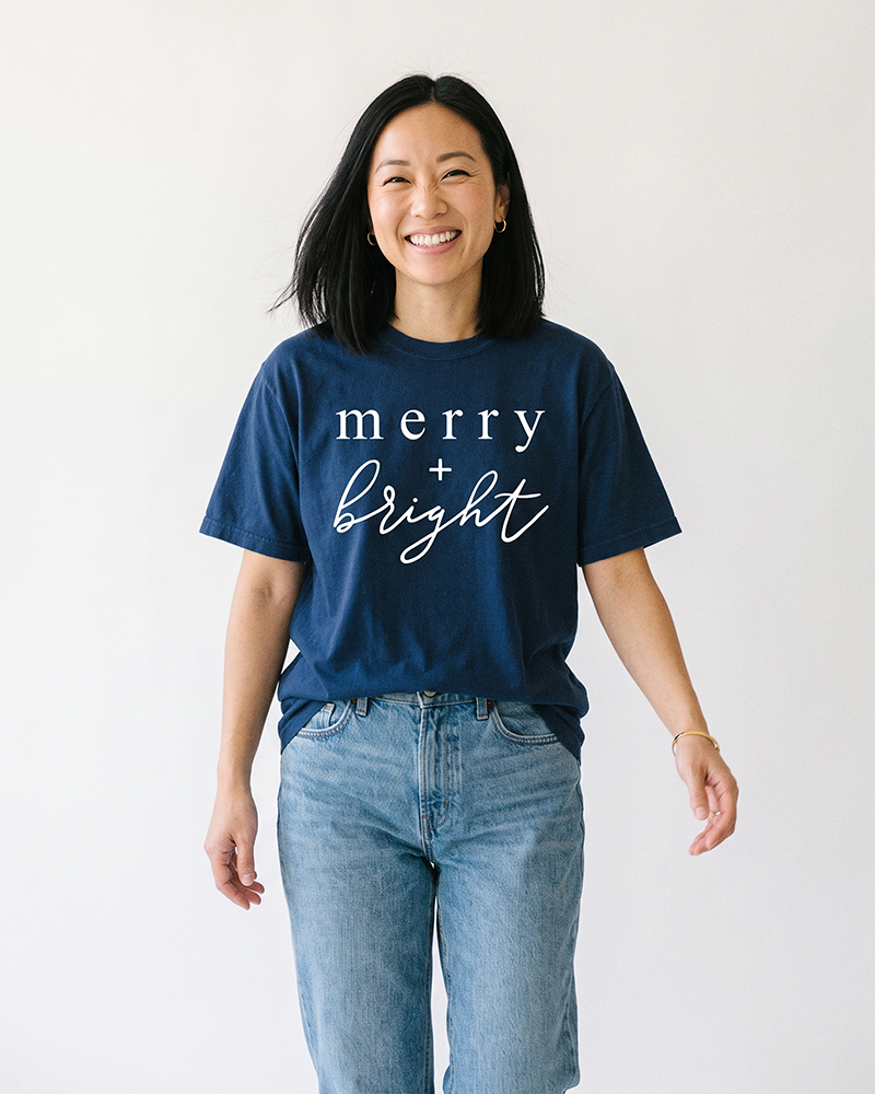 Woman wearing true navy Merry + Bright heavyweight holiday graphic tee
