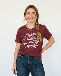 Woman wearing cardinal red Merry Christmas Ya Filthy Animal funny Christmas tee