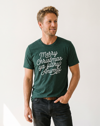 Man wearing emerald green Merry Christmas Ya Filthy Animal funny holiday tee