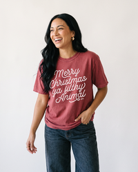 Woman wearing brick Merry Christmas Ya Filthy Animal graphic tee