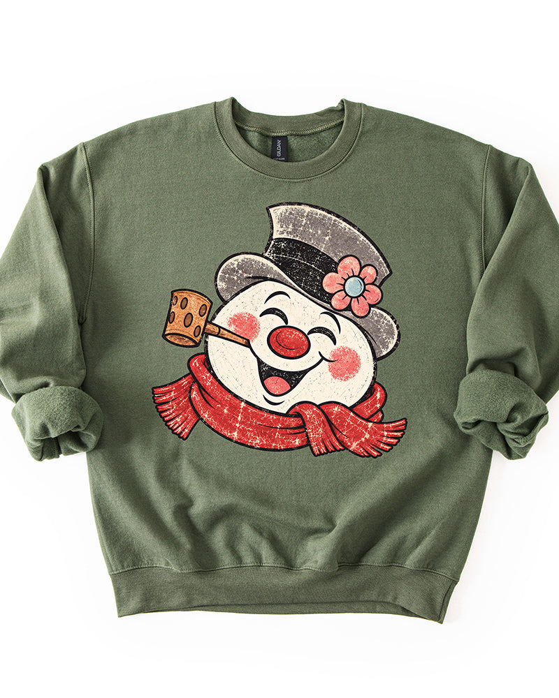Military Green Christmas crewneck sweatshirt featuring a large distressed retro snowman with red scarf, pipe, and flowered top hat.