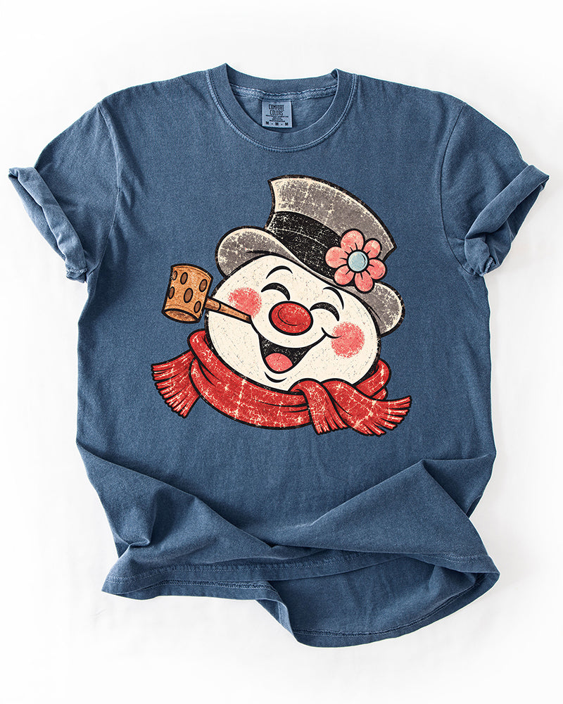 Denim blue Comfort Colors heavyweight tee featuring a large smiling retro snowman Christmas graphic.