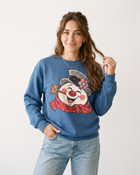Woman wearing an Indigo blue Retro Frosty Snowman Christmas crewneck sweatshirt with oversized vintage snowman graphic and jeans.