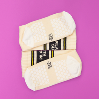 Close-up of woven-in honeycomb grip pattern on bottom of ivory Pilates Slut socks