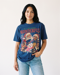 Woman wearing a True Navy retro Christmas characters heavyweight tee with a festive vintage holiday collage and light blue jeans.