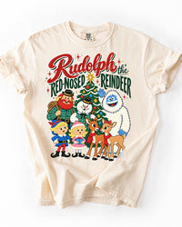 Ivory Comfort Colors heavyweight Christmas T-shirt featuring vintage Rudolph the Red-Nosed Reindeer characters and retro red-and-green holiday lettering.