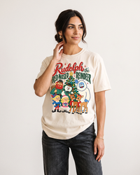 Woman with dark hair wearing an Ivory Rudolph vintage Christmas heavyweight graphic tee with black jeans, featuring classic holiday characters.
