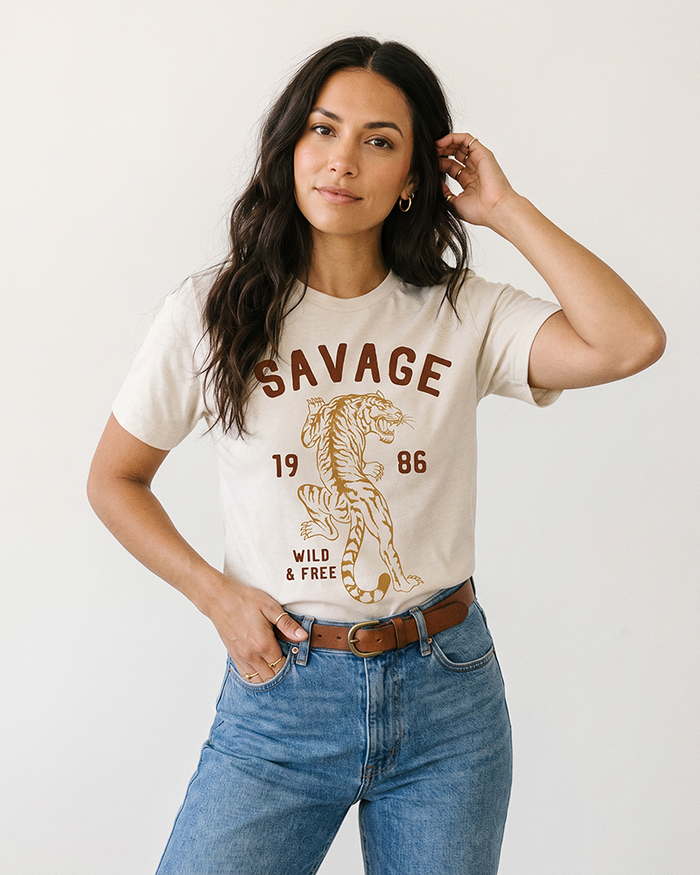 Woman wearing Savage Wild & Free vintage tiger graphic tee with blue jeans and brown belt