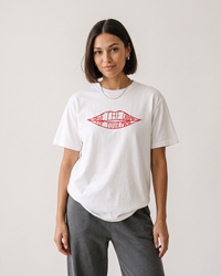 Woman with dark bob haircut modeling a white Save The Drama For Your Mama heavyweight graphic tee and gray pants.
