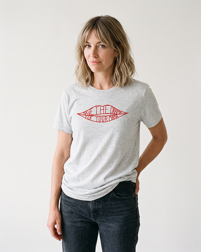 Blonde woman modeling ash gray Save The Drama For Your Mama T-shirt with dark jeans.