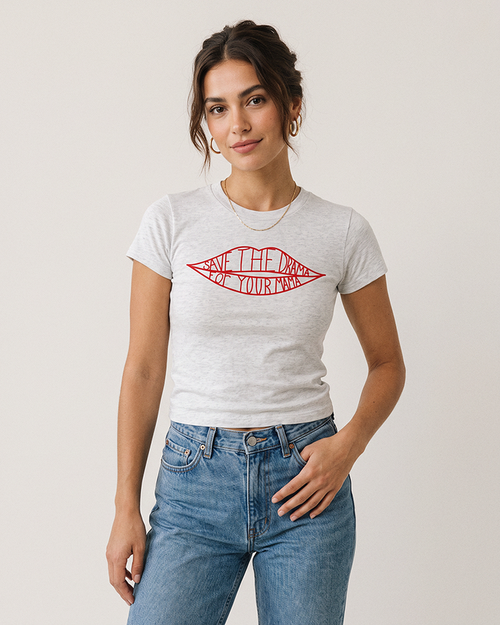 Woman wearing an ash grey '90s-inspired baby tee with red lips graphic and blue jeans.