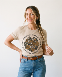 Woman wearing heather tan Soul on Fire tiger and rose graphic tee with blue jeans
