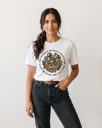 Woman wearing white Soul on Fire tiger and rose graphic tee with black jeans