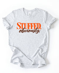 Ash gray Stuffed, Obviously lightweight Thanksgiving T-shirt with retro orange block lettering and brown cursive script.