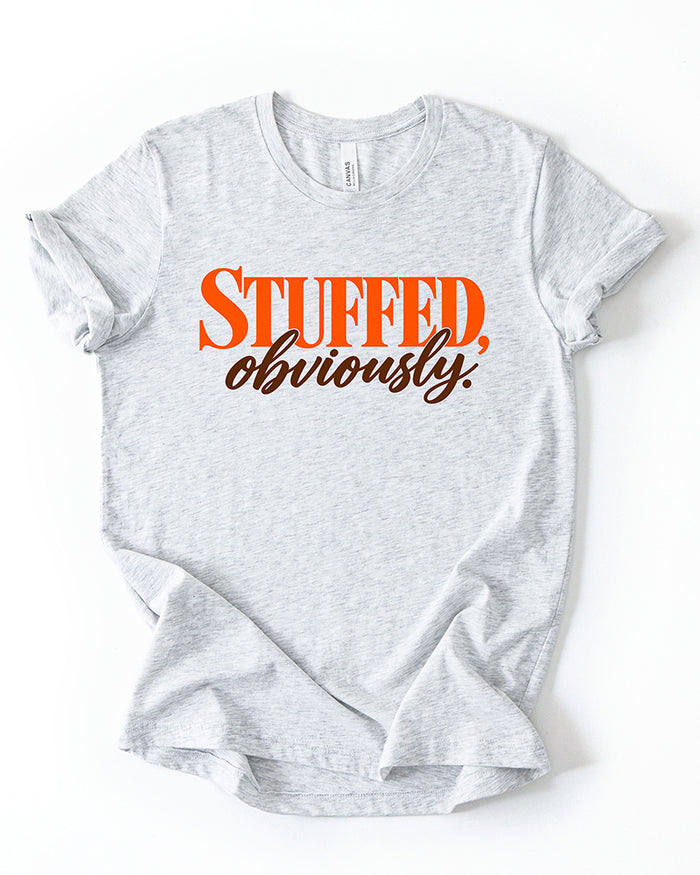 Ash gray Stuffed, Obviously lightweight Thanksgiving T-shirt with retro orange block lettering and brown cursive script.