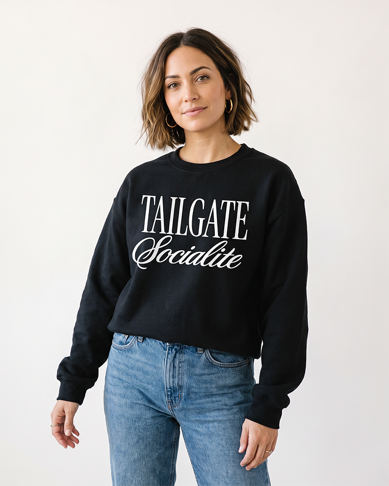 Woman wearing black Tailgate Socialite crewneck sweatshirt with white graphic, casual game day sweatshirt