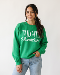 Woman wearing green Tailgate Socialite crewneck sweatshirt with white graphic, game day apparel