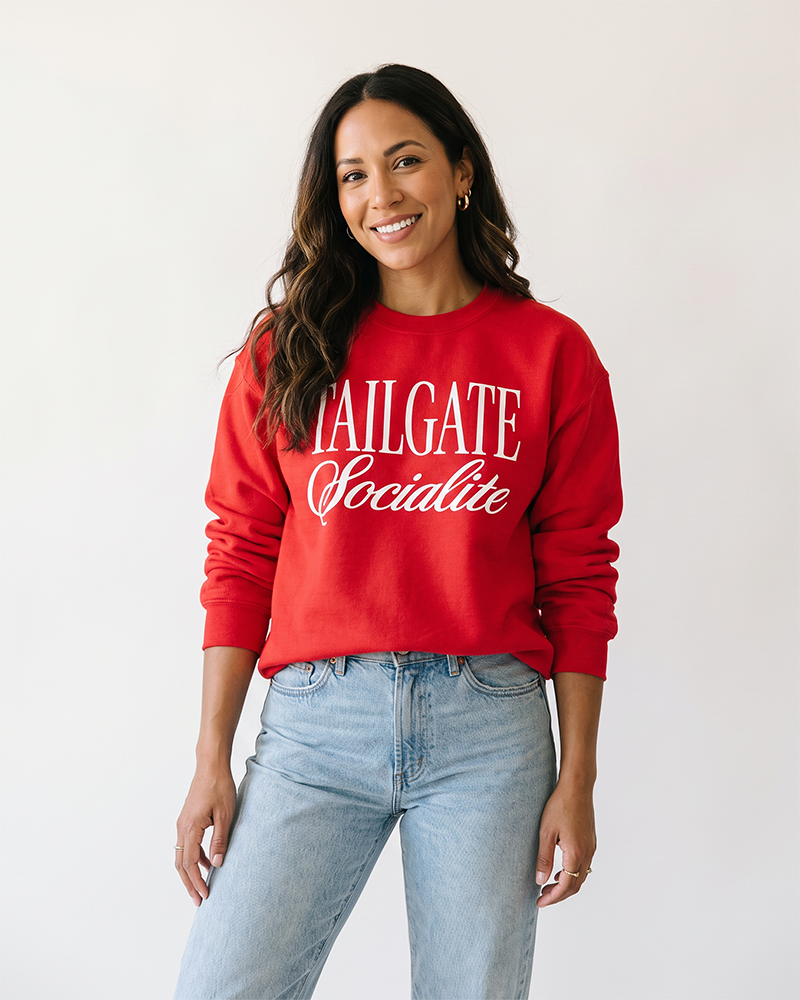 Woman wearing red Tailgate Socialite crewneck sweatshirt with white graphic, women's football game day outfit