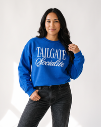 Woman wearing royal blue Tailgate Socialite crewneck sweatshirt with white graphic for football game day