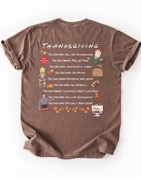 Back of espresso brown Friends Thanksgiving graphic T-shirt featuring illustrated references to the football game, Chandler's box, and other holiday episodes.