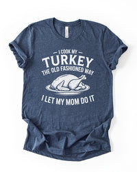 Heather Navy funny Thanksgiving lightweight tee featuring white lettering that reads I Cook My Turkey the Old Fashioned Way I Let My Mom Do It.