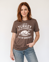 Red-haired woman modeling a Heather Brown funny Thanksgiving lightweight tee with white turkey graphic, paired with blue jeans.